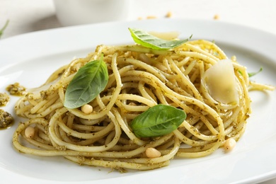 Photo of Delicious basil pesto pasta on plate, closeup