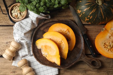 Cut fresh ripe pumpkin on wooden table, flat lay