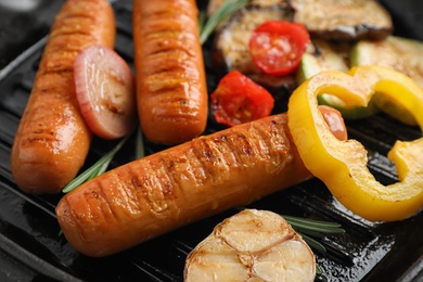 Delicious sausages and vegetables in grill pan, closeup