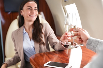 Image of Couple clinking glasses of champagne during flight