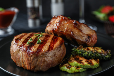 Photo of Closeup view of delicious grilled beef medallions served on table