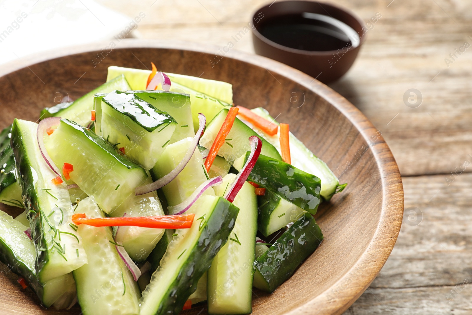 Photo of Plate with delicious cucumber salad on table, closeup