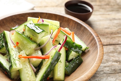 Photo of Plate with delicious cucumber salad on table, closeup