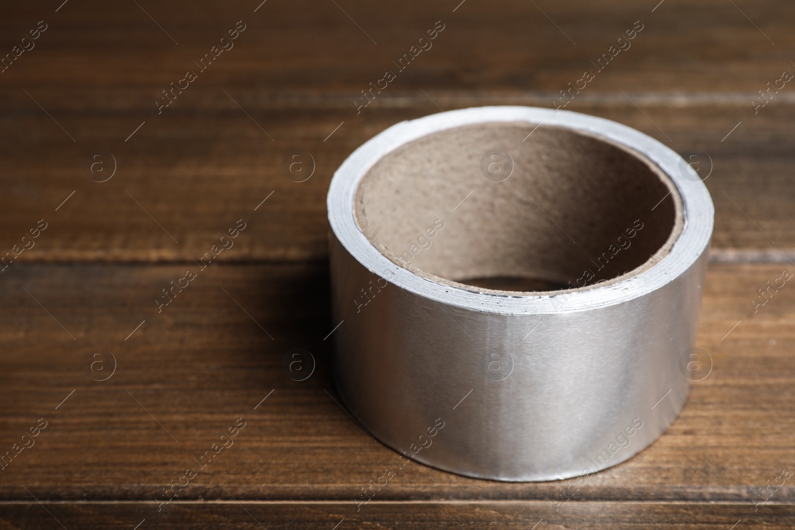 Photo of Roll of adhesive tape on wooden table. Space for text