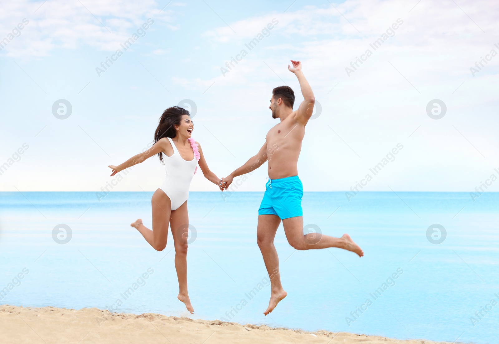 Photo of Happy young couple having fun together on beach near sea