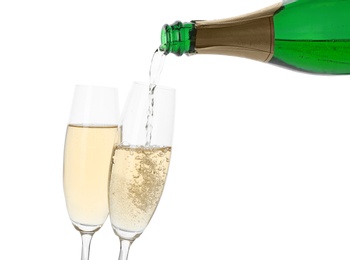 Pouring champagne from bottle into glass on white background