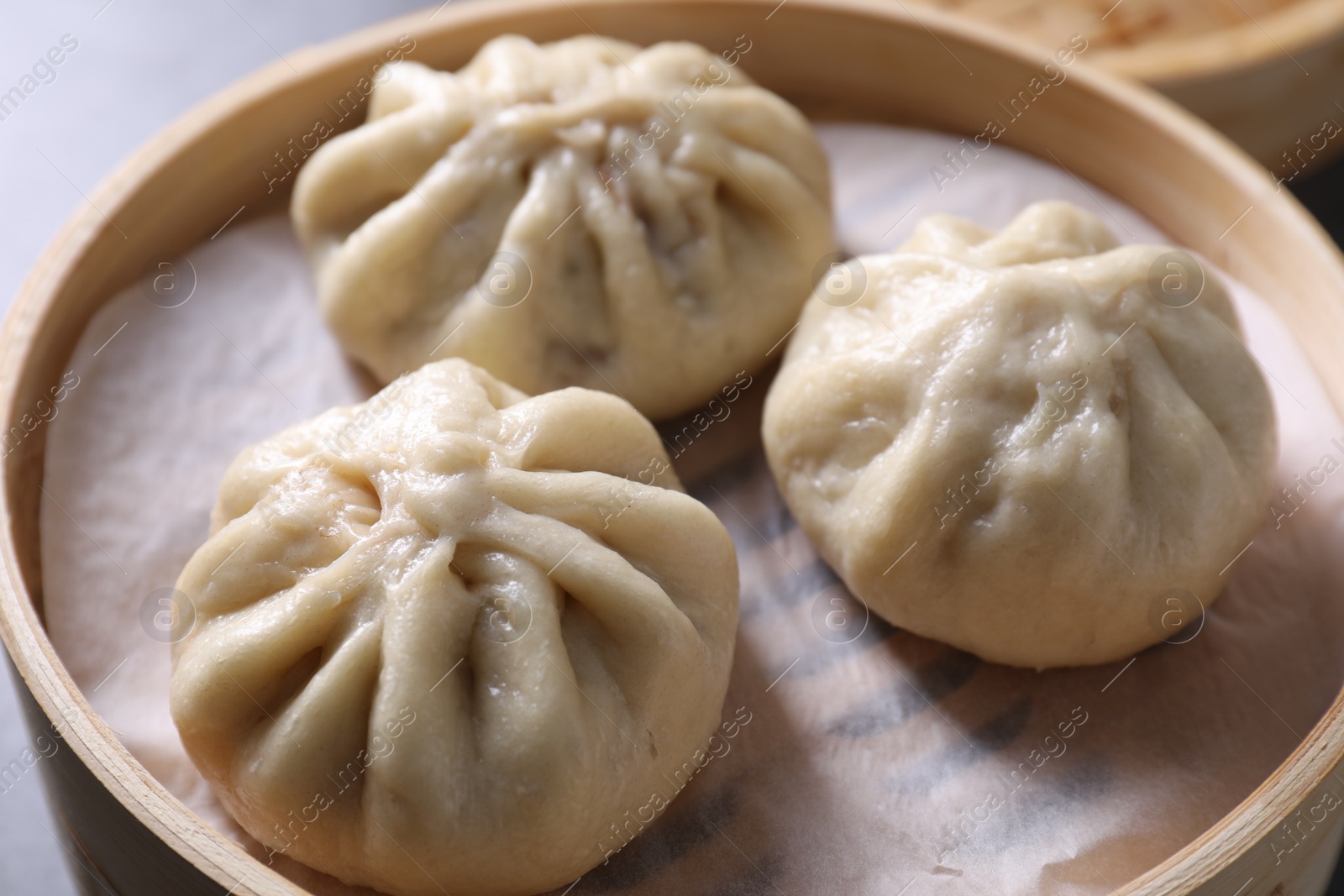 Photo of Delicious bao buns (baozi) on table, closeup