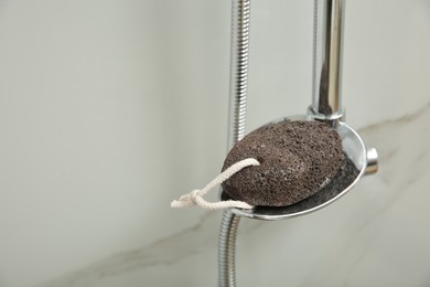 Photo of Pumice stone on metal shelf in bathroom, space for text