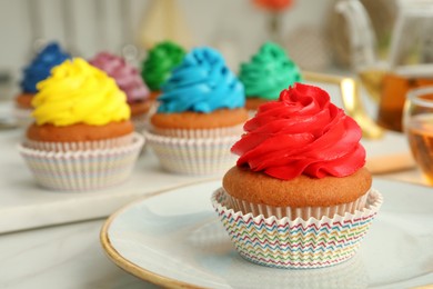 Photo of Delicious cupcake with red cream on white table, closeup