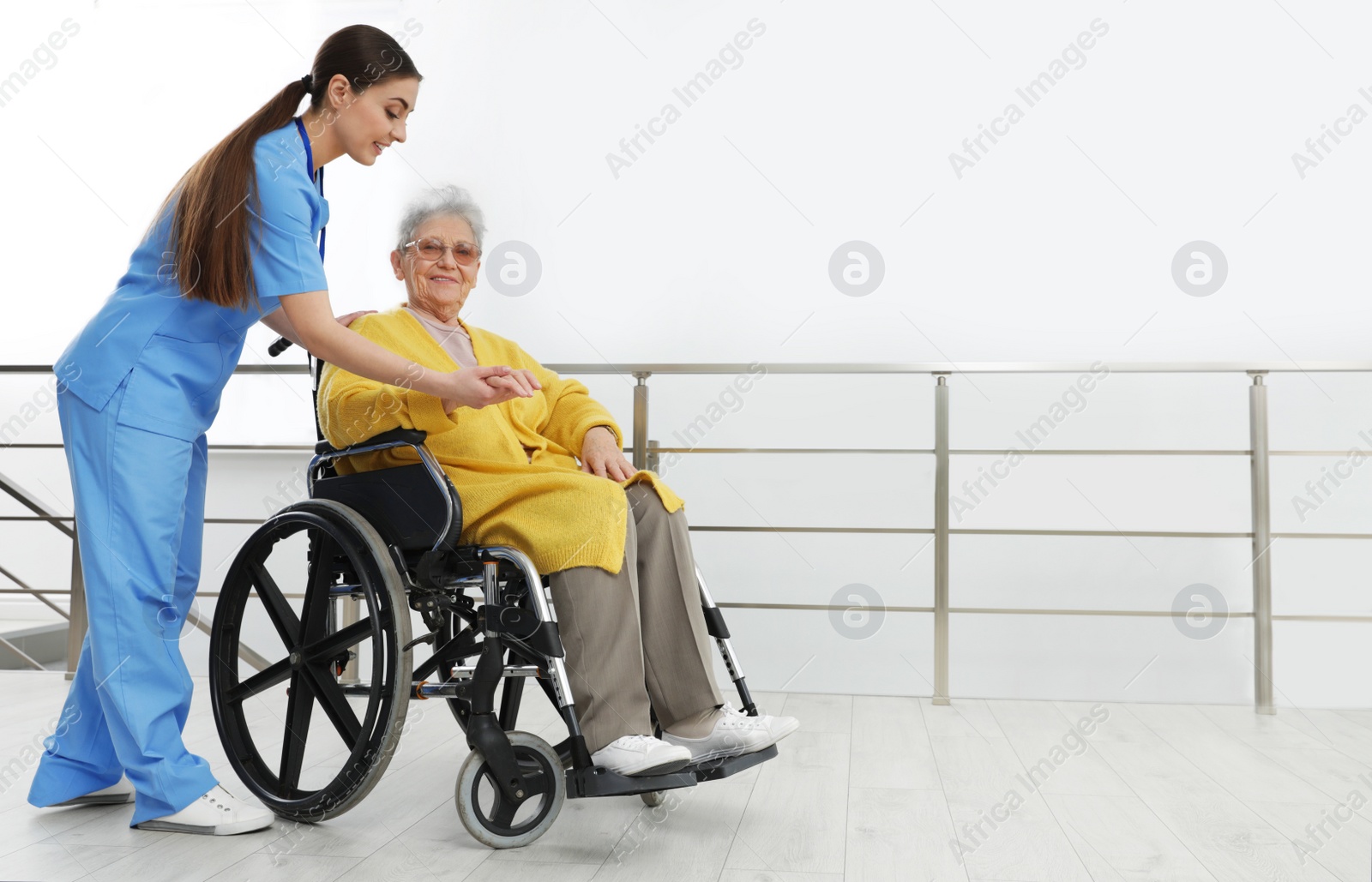 Photo of Nurse assisting senior woman in wheelchair at hospital