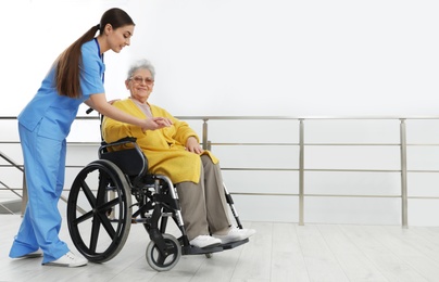 Photo of Nurse assisting senior woman in wheelchair at hospital