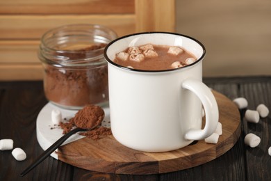 Photo of Cup of aromatic hot chocolate with marshmallows and cocoa powder served on table