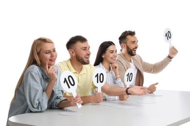 Photo of Panel of judges holding signs with highest score at table on white background