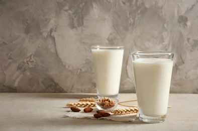 Photo of Glasses with milk and nuts on table