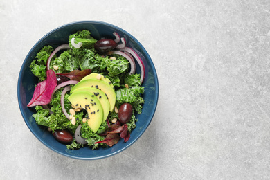 Tasty fresh kale salad on light grey table, top view. Space for text