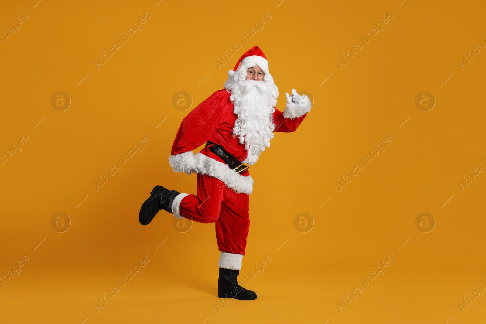 Photo of Merry Christmas. Santa Claus posing on orange background