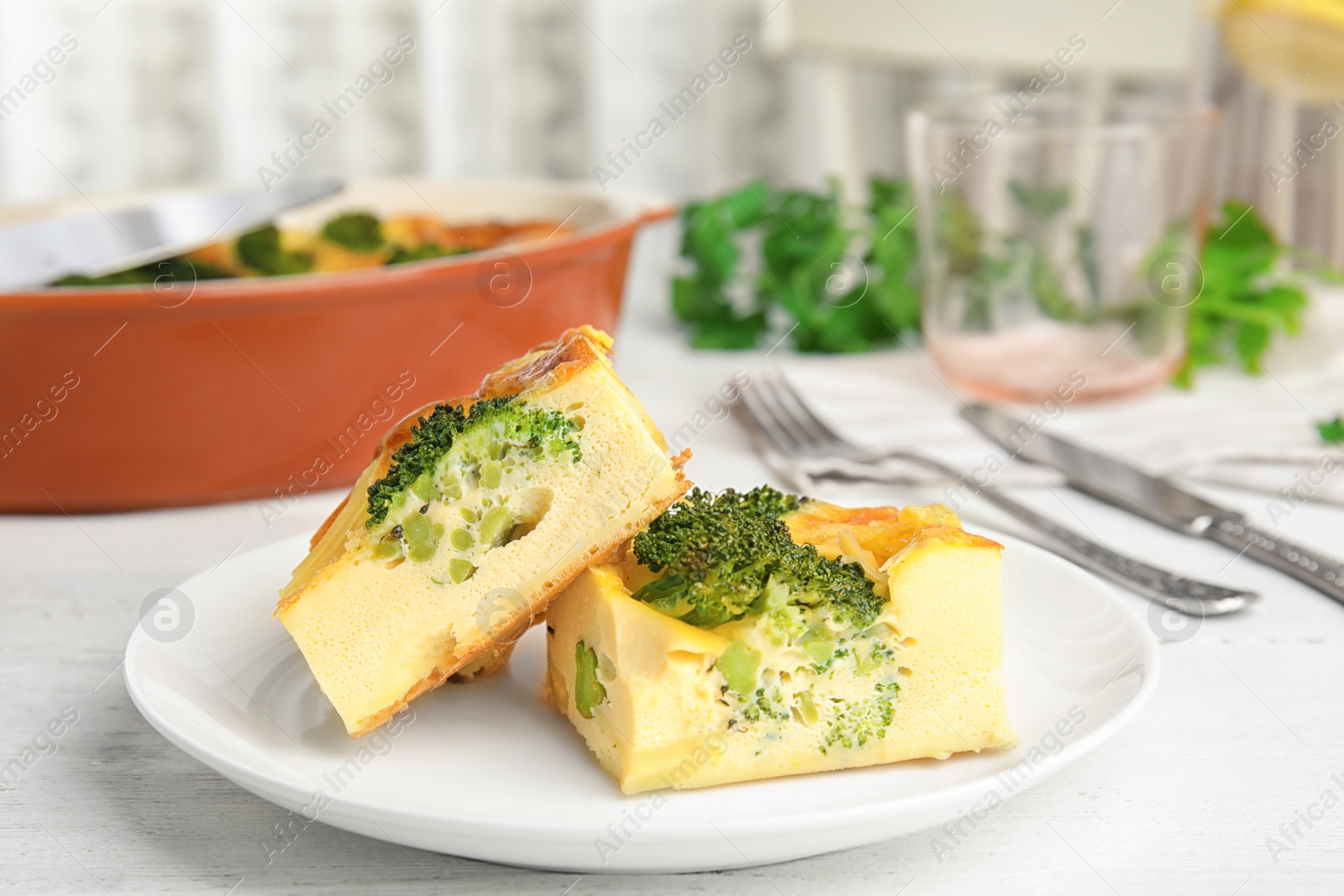 Photo of Tasty broccoli casserole served on white wooden table