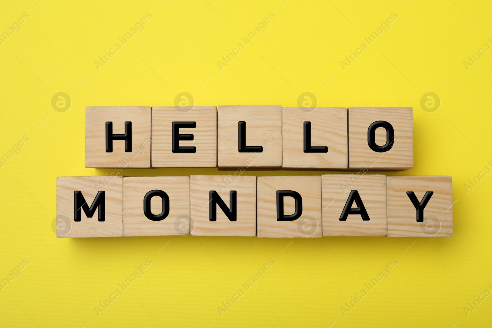 Photo of Wooden cubes with message Hello Monday on yellow background, flat lay