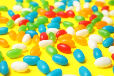 Photo of Delicious jelly beans on color background, closeup