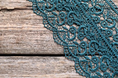 Photo of Beautiful lace on wooden table, top view. Space for text