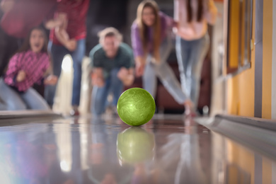 Photo of Group of friends in bowling club, focus on ball