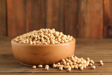 Bowl with soy on wooden table. Edible legume