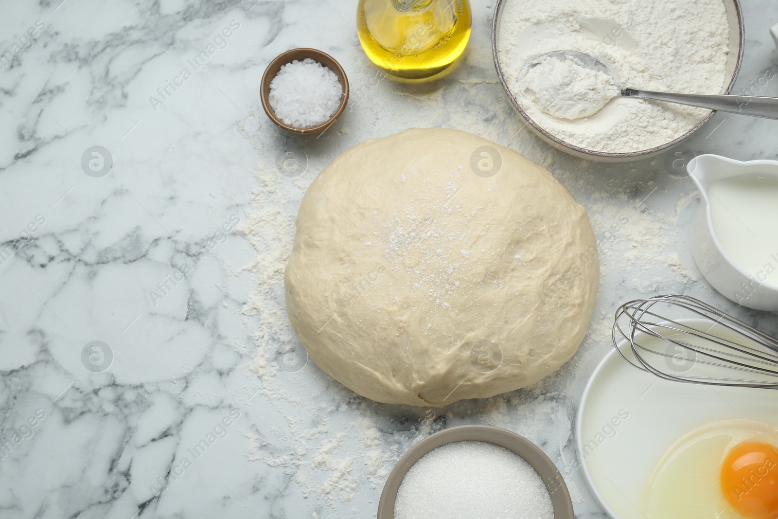 Photo of Fresh yeast dough and ingredients on white marble table, flat lay. Space for text