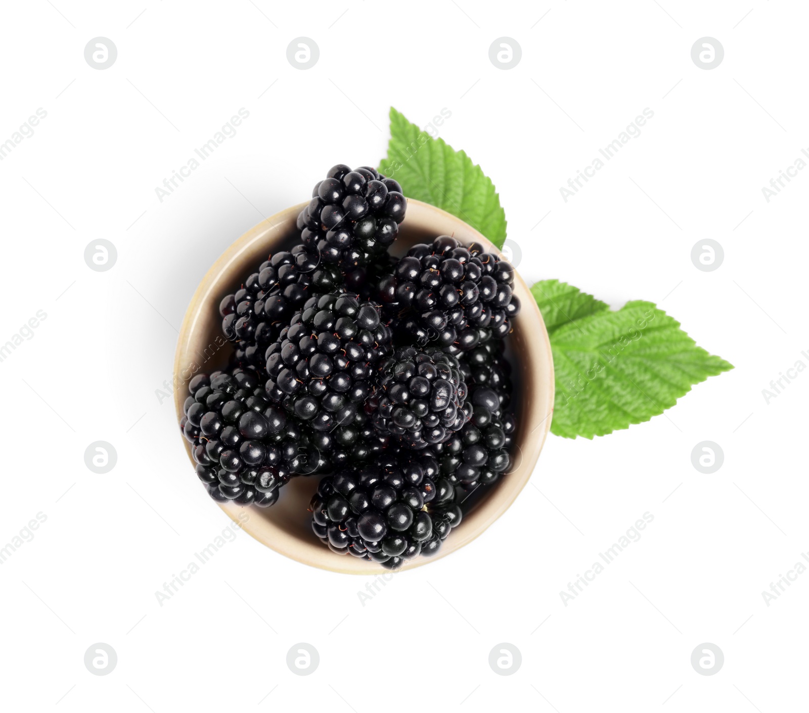 Photo of Bowl of ripe blackberries and green leaves isolated on white, top view