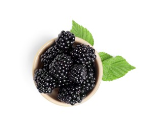 Photo of Bowl of ripe blackberries and green leaves isolated on white, top view
