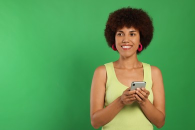 Photo of Happy young woman with smartphone on green background. Space for text