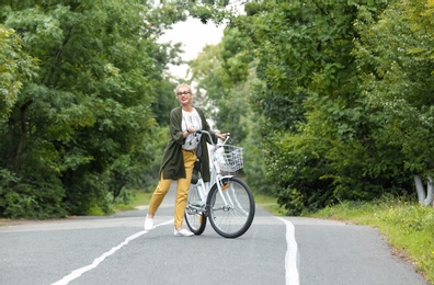 Photo of Beautiful woman in casual outfit with bicycle outdoors