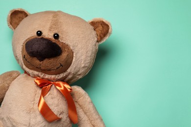 Photo of Cute teddy bear on turquoise background, top view. Space for text