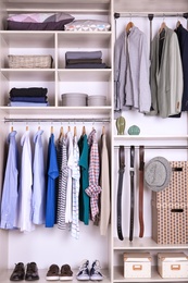 Photo of Large wardrobe with different clothes, home stuff and shoes