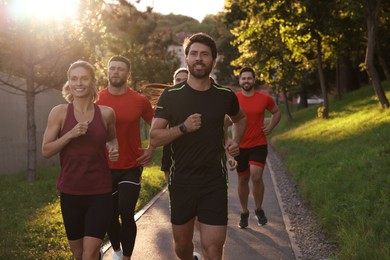 Photo of Group of people running outdoors on sunny day