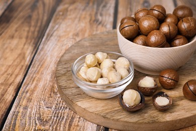Photo of Delicious organic Macadamia nuts on wooden table. Space for text