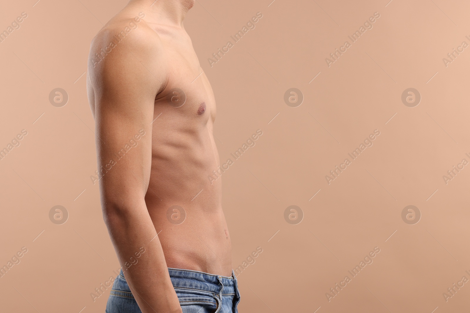 Photo of Shirtless man with slim body on beige background, closeup. Space for text