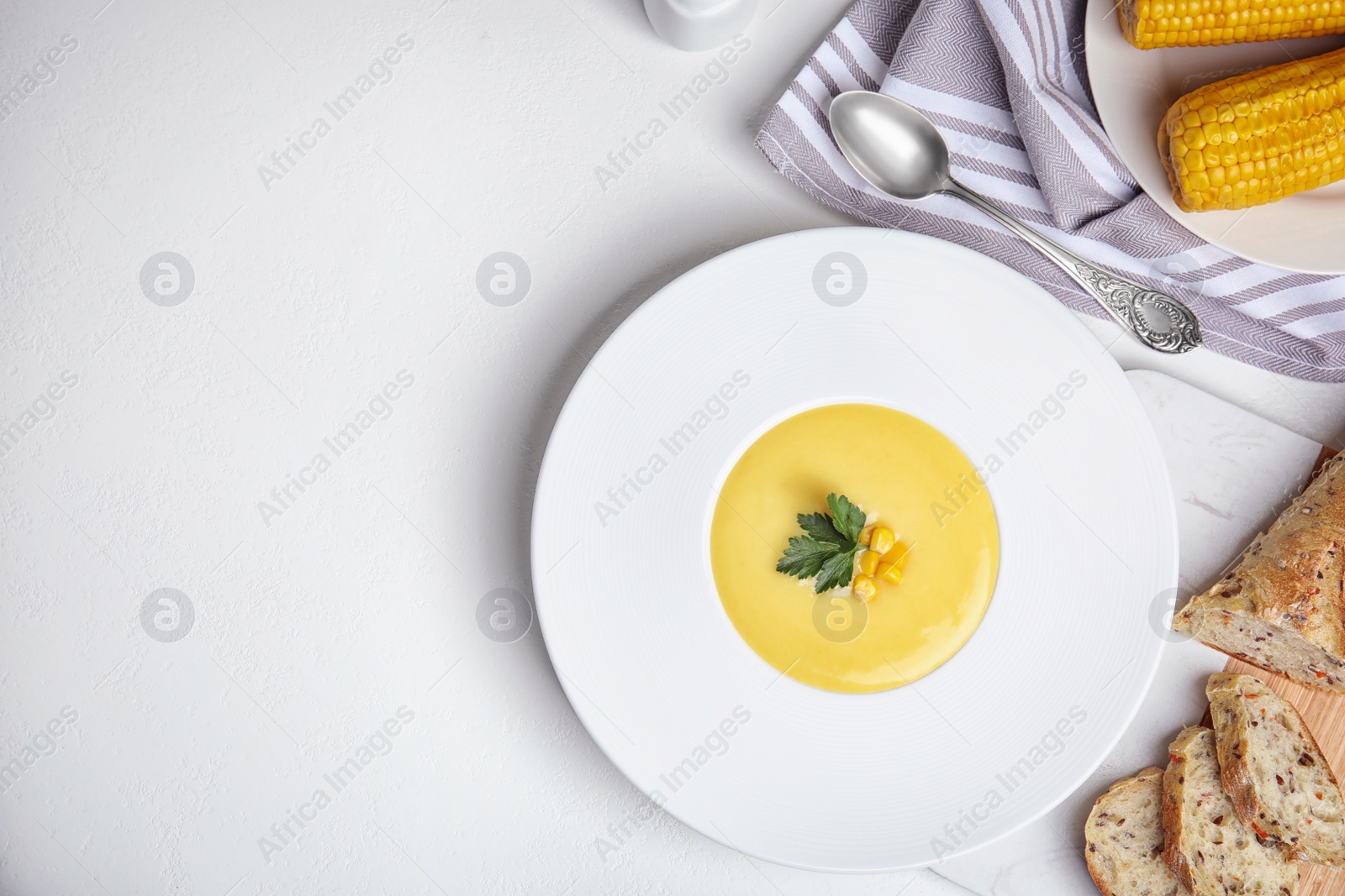 Delicious corn cream soup served on white table, flat lay. Space for text Photo of Delicious corn cream soup served on white table, flat lay. Space for text