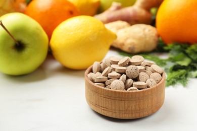 Photo of Dietary supplements in wooden bowl and products on white table, closeup. Space for text