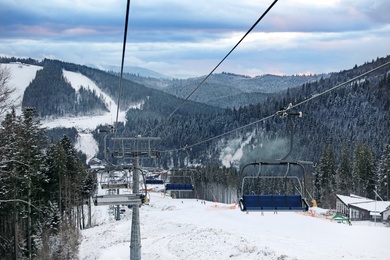Photo of Beautiful view of mountains and chairlift at ski resort. Winter vacation