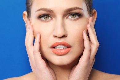 Photo of Young woman wearing beautiful lipstick on color background