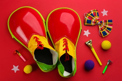Photo of Flat lay composition with clown's accessories on red background