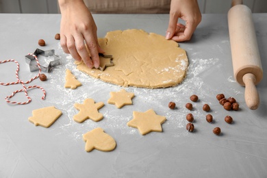 Young woman preparing Christmas cookies on table