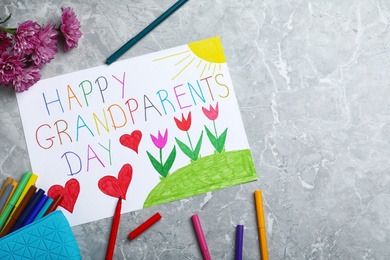 Photo of Beautiful drawing on grey marble table, flat lay. Happy Grandparents Day