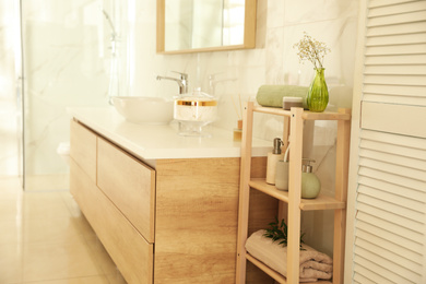 Photo of Shelving unit with toiletries in stylish bathroom interior 