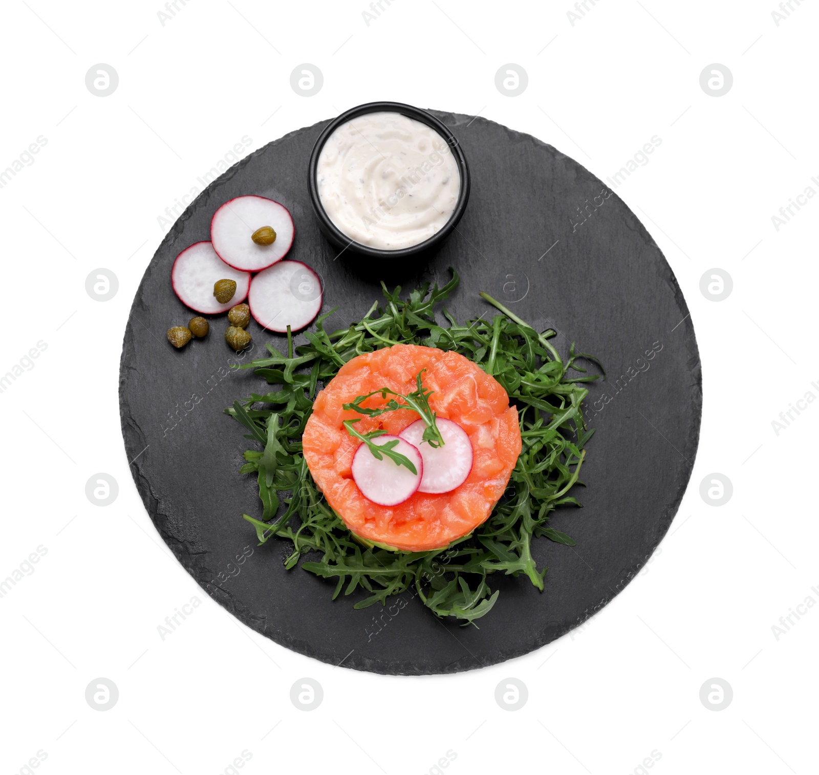 Photo of Tasty salmon tartare with radish, capers, arugula and sauce isolated on white, top view