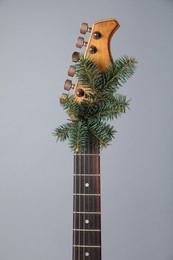 Photo of Guitar with fir tree branch on grey background. Christmas music