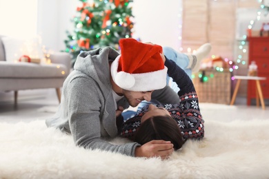 Photo of Happy young couple celebrating Christmas at home
