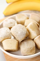 Photo of Frozen banana puree cubes and ingredient on light grey table, closeup