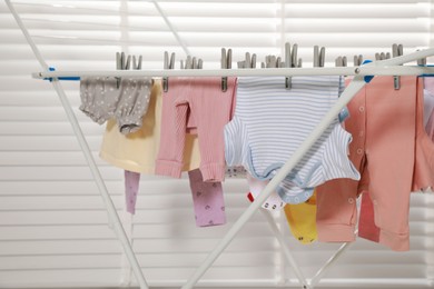 Photo of Clean laundry hanging on drying rack indoors