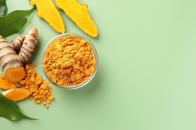 Photo of Aromatic turmeric powder, raw roots and leaves on green background, flat lay. Space for text